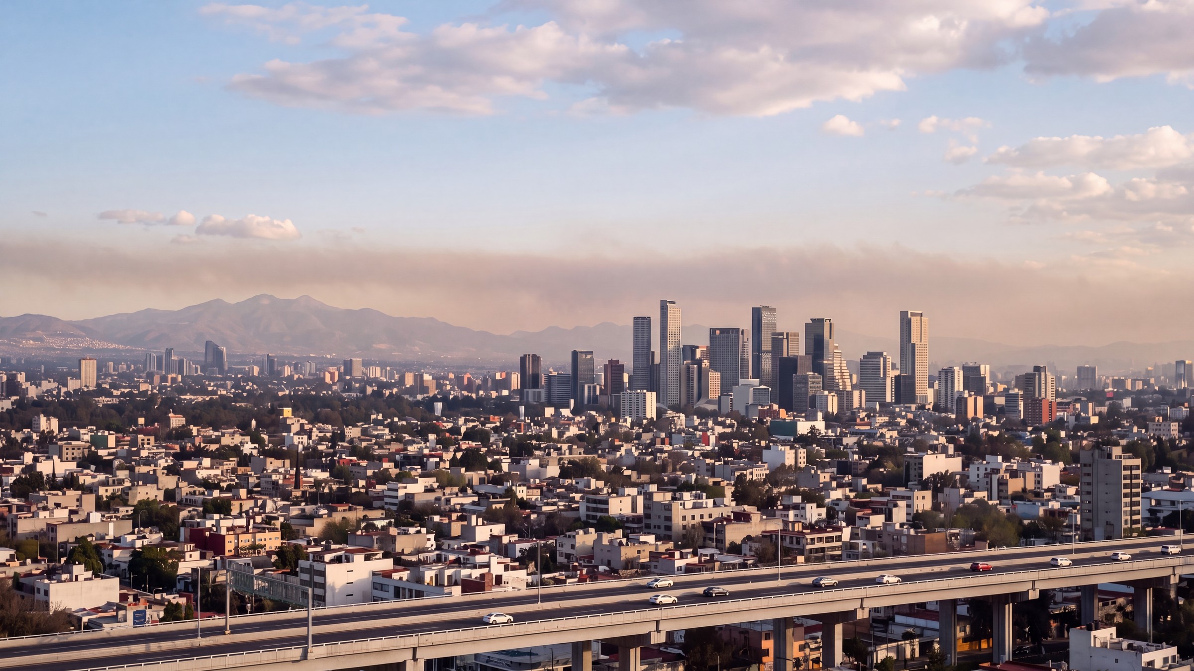 Autopista de la Ciudad de México con tráfico y una capa de contaminación sobre las montañas
